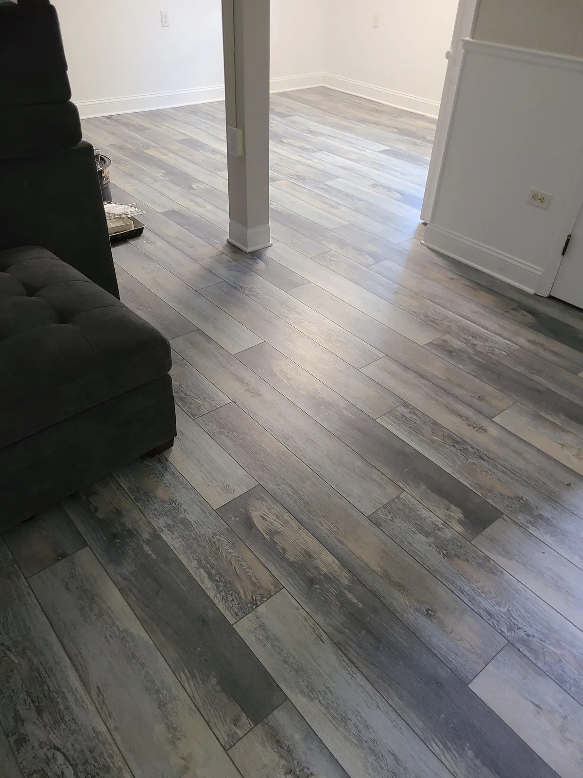 Coastal gray weathered-wood LVP flooring in a living room — installed by Threshing Floors
