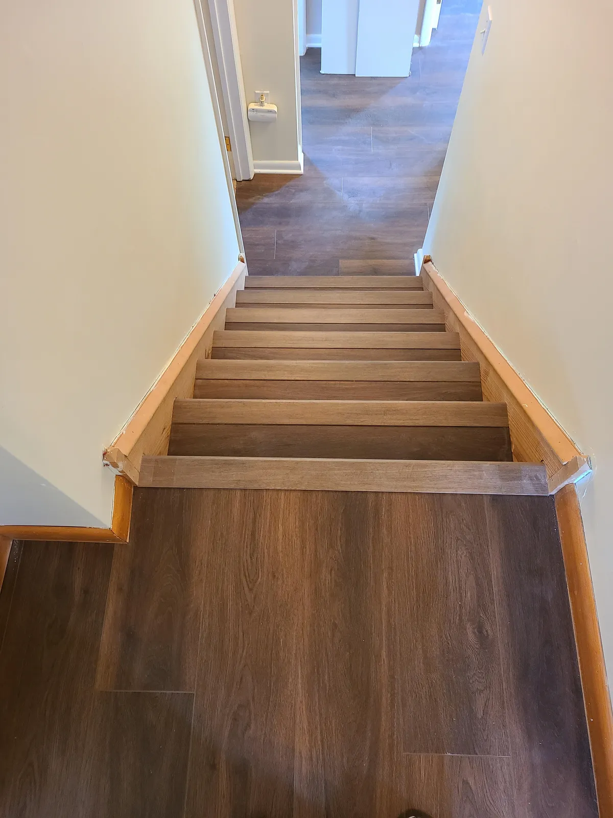 Oak wood-look LVP stair treads and landing — installed by Threshing Floors